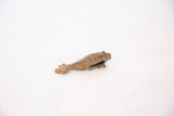 Angled view of a vintage bronze fish pendant detailing its openwork and textured surface.