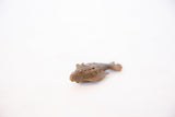 Angled view of a handmade bronze fish pendant showing its eye and coiled wire body design.