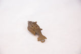 Angled view of the bronze fish pendant's sculpted tail and wirework details.