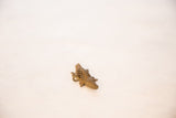 Angled view of a handmade bronze crocodile pendant with a textured mesh back.