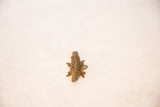 Overhead view of a vintage bronze crocodile pendant highlighting its openwork mesh back.