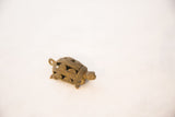 A vintage bronze turtle pendant seen from an angle, highlighting its textured wire-work.