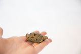 Vintage bronze turtle pendant with aged patina held in hand to show its actual size.
