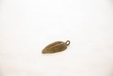 Vintage African bronze bean pod pendant with textured surface and aged patina.