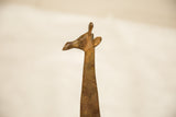 Detailed profile of a vintage copper giraffe's head with a rich, textured patina.