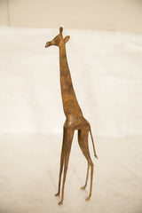 Full profile of a vintage handmade copper giraffe with a mottled, aged patina.