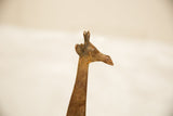 The sculpted head of a vintage copper giraffe showing its aged, rustic patina.