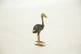 Side profile of a bronze ostrich showing its dark textured body and smooth, slender neck.