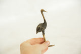 A small vintage bronze ostrich held in hand, showing its two-tone patina and scale.