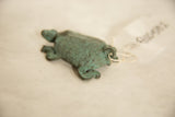 Patinaed green copper turtle, close-up showing textured shell and curled tail.