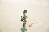 Stylized profile of a vintage African farmer figure showing its oxidized copper patina.