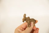 Hand holding a vintage African bronze water buffalo, highlighting its rich, textured patina.