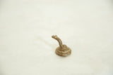 The alert, raised head and rustic coiled body of a vintage African bronze serpent.