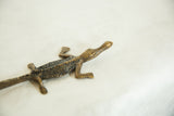Angled view of a vintage bronze crocodile, highlighting its textured back.