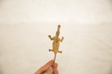Underside view of a vintage bronze crocodile showing its rustic, handmade texture.