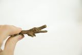 The hand-cast texture and aged patina on a vintage African bronze alligator.