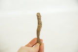 A hand holds the vintage African bronze eel, showing its small scale and textured finish.