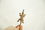 The small scale and light patina of a vintage bronze alligator held in hand.
