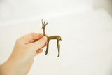 Vintage African bronze gazelle fawn, handmade with aged patina, held in a hand.