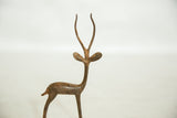 Profile view of the alert head and antlers of a vintage copper gazelle sculpture.