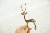 A hand holds the vintage copper gazelle, showing its delicate scale and rustic patina.
