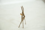 The alert face, ears, and tall horns of a handmade vintage African bronze gazelle.