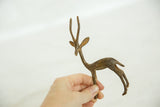 A hand holding the alert vintage bronze gazelle to illustrate its size.