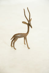 A vintage handmade bronze gazelle stands alert, showing its right profile and textured finish.