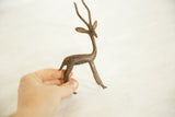 Vintage African bronze gazelle held in a hand to demonstrate its scale.