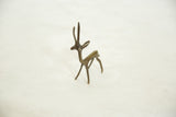 The alert posture and slender form of a vintage handmade African bronze gazelle sculpture.