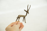 Handmade form and small scale of a vintage bronze gazelle held in hand.