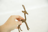 Vintage bronze gazelle held in hand, showing its small scale and handmade texture.