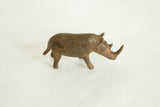 Side profile of a small African bronze rhinoceros with a dark, time-worn patina.