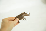 Handmade vintage bronze rhinoceros held to show its compact size and texture.
