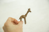 Vintage African bronze giraffe figurine held to show its petite scale and textured surface.