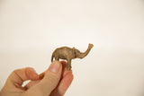 Textured vintage African bronze elephant figurine, held to reveal its small scale.