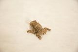 Angled overhead view showing the rustic texture on the back of a vintage bronze frog.