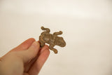 Angled view of the vintage bronze frog showcasing its bumpy, aged texture.