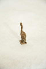 Textured back and slender neck of a vintage African bronze ostrich, viewed from behind.