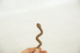 Hand holding vintage African bronze striped snake sculpture, head up.