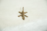 Top view of a vintage bronze striped lizard showing its rustic, handmade texture.