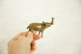 Vintage African bronze elephant held in hand, displaying aged finish.