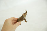 Vintage African speckled metal elephant held in hand, showing aged patina.