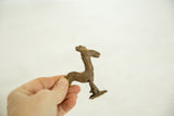 Handmade vintage bronze rooster sculpture held to illustrate its small scale.