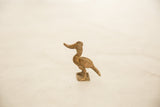 The elegant profile of a handmade African bronze bird showing its curved beak and neck.
