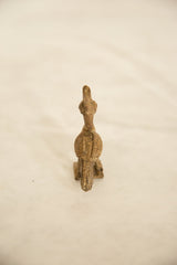Rear view of a vintage bronze bird sculpture showing its textured, patterned back.