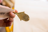 African bronze hut pendant with a rich, aged patina and textured surface.