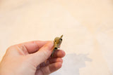 Frontal view of the vintage bronze elephant pendant's hollow trunk and textured surface.