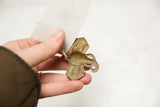 Vintage African bronze elephant pendant held to illustrate its scale and texture.
