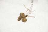 Vintage bronze elephant pendant shown with its attached paper inventory tag.